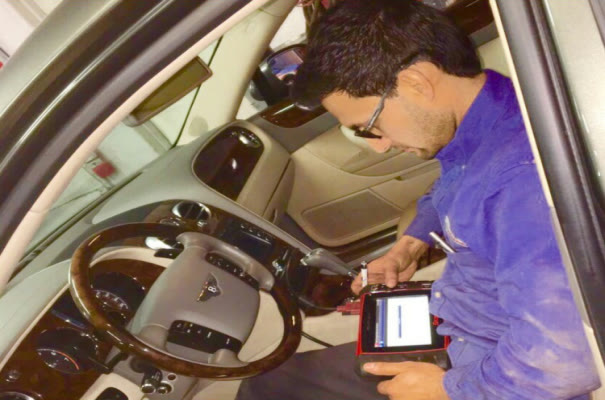 A scan tool plugged in from the driver's seat to read the car's modules